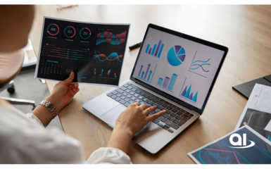 Person analysiert Daten am Laptop und in gedruckten Berichten mit Diagrammen und Grafiken auf einem Holztisch.